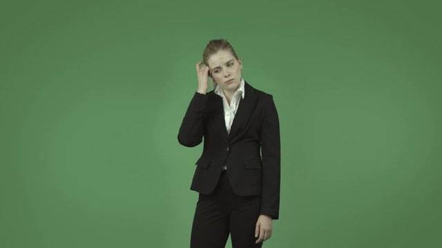 attractive caucasian business girl isolated on green thinking scratching head