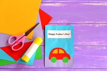 Greeting card with message Happy father's day. Paper postcard children's crafts. Idea kids gift for dad. Sheets of colored paper, scissors, glue on lilac wooden background