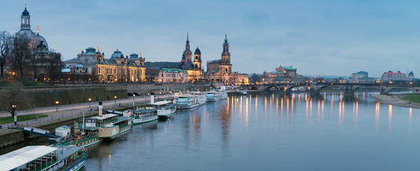 Night panorama of Dresden Old town with reflections in Elbe river and passenger ships