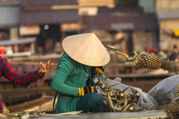 Rolgordijnen Vietnamese woman with typical conical hat ( sugegasa),  cut pineapple fruits in the  Cai Rang floating market on the Mekong delta. Can Tho, Vietnam © nnerto
