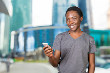 Portrait of a smiling african man using smartphone over white background