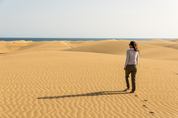Girl walking on sand dunes in Gran Canaria, Spain