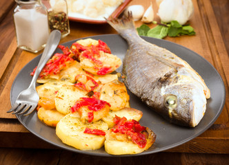 roasted sea bream with potatoes on wooden