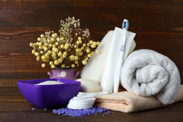 personal hygiene items with decorative sprigs on a brown wooden background