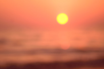 Blur tropical sunset beach with bokeh sun light wave abstract background. Travel concept.