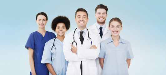 Fototapeta na wymiar group of happy doctors over blue background