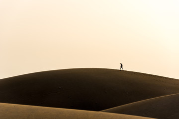 Fototapeta na wymiar Men walking in the desert of gran canaria, spain