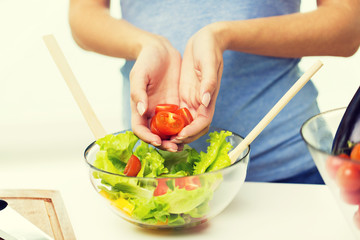close up of woman cooking vegetable salad at home