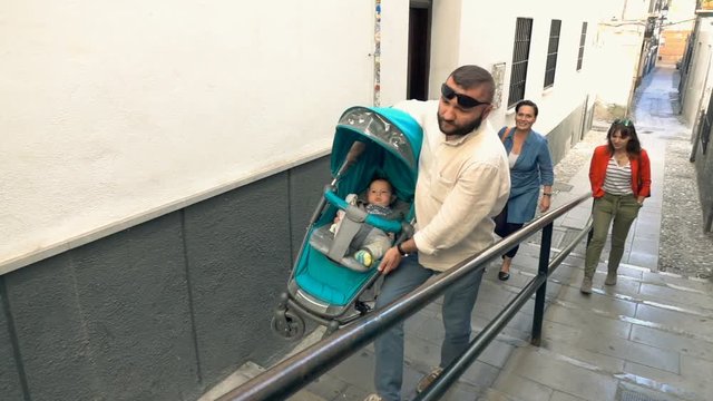 Friends with baby in stroller walking in city, super slow motion 120fps
