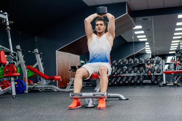 young muscular sporty man doing exercises in gym 