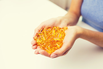 Obraz premium close up of woman hands holding pills or capsules