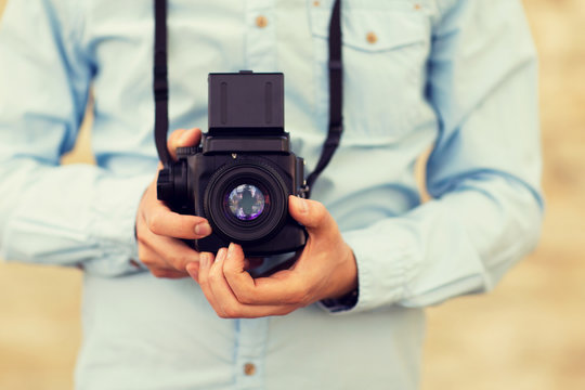 close up of hipster man with film camera in city