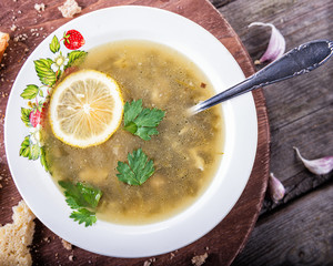 Green soup in a cup with a spoon on a wooden board.