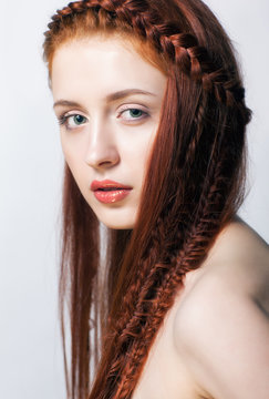Young  woman with ginger braids hairdo on white background