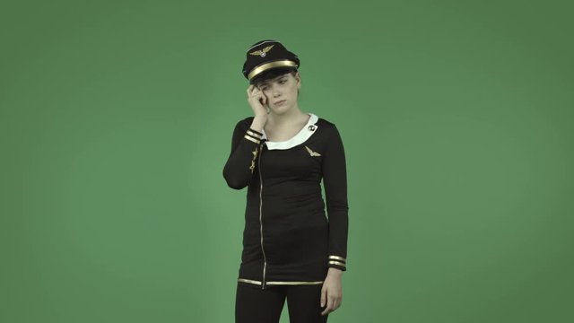 attractive caucasian air hostess isolated on green thinking scratching head