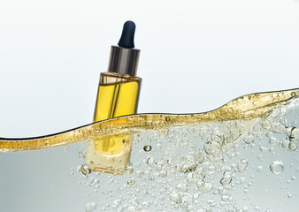 The bottle of the yellow cosmetic oil in the yellow  oil emulsion wave