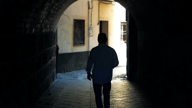 Silhouette of man walking through tunnel in city, super slow motion 120fps 
