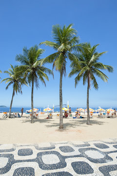 Classic view of Ipanema Beach Rio de Janeiro boardwalk with palm trees and blue sky
