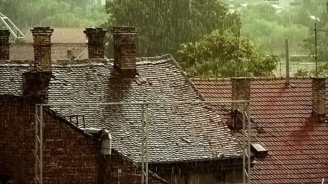 Heavy Rain Falling over houses in rural background 
