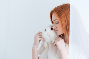 Fototapeta premium Redhead woman posing with rabbit