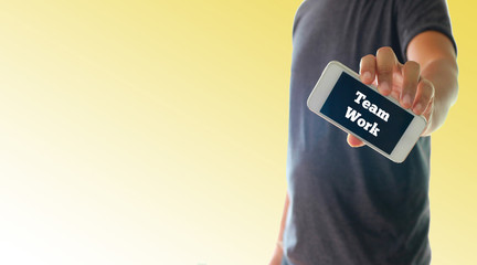 a man using hand holding the smartphone with text team work on d