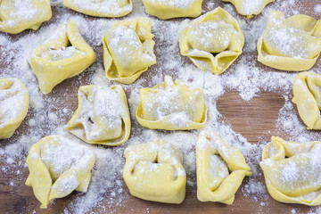 Row of raviolis in flour with one place in form of heart