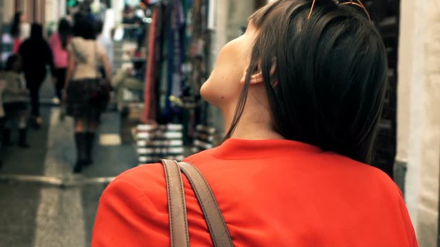 Young woman at bazaar looking at souvenirs, super slow motion 120fps
