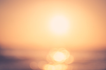 Blur tropical sunset beach with bokeh sun light wave abstract background. Travel concept.