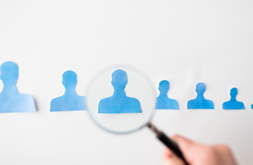 close up of paper human shapes on white board