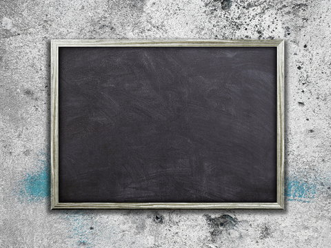 Close-up of one blank blackboard poster frame on gray weathered dirty concrete wall background