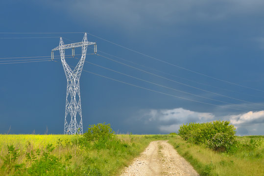 Electric power lines in rape field after summer storm
