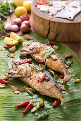 fried mackerel with asian heab on the banana leaf. Cooking  in Asian kitchen. Spicy meal.