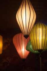 4 colorful Chinese paper lanterns hanging in the darkness