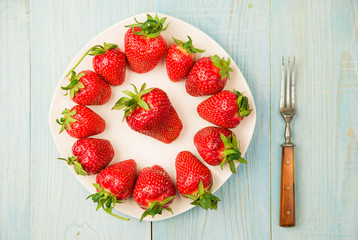 Ripe strawberry fruits on a white plate