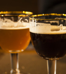 Two glasses of draught beer .