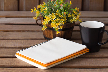 Paper notebook and coffee cup on a table 