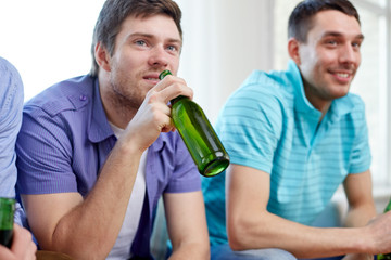 happy male friends drinking beer at home