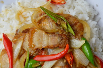 stir fried crispy fat pork with sweet chili and slice onion on rice