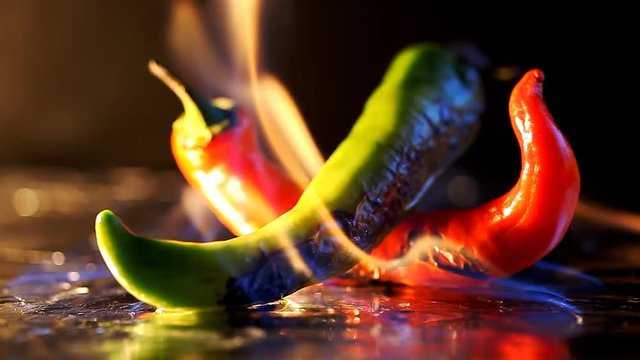 hot pepper in fire arms   /   hot pepper in flames on a black background