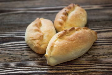Traditional russian pies on wooden background.