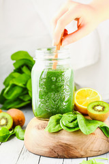 green detox smoothie with spinach in a jar, kiwi and citrus