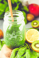 green detox smoothie with spinach in a jar, kiwi and citrus