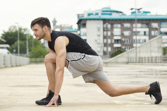 Fit young man doing stretches outdoors