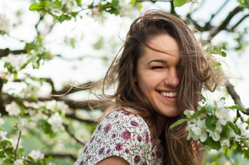 Close-up portrait of cheerful woman relaxing in spring orchard