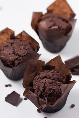 Chocolate muffins on a white background, homemade bakery, close up, selective focus