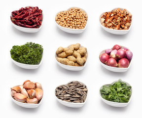 variety of ingredients in a heart shaped bowl, isolated on white.
dried chili, coriander seeds, lemon grass, parsley, peanuts, shallot, garlic, sunflower seeds, fresh coriander