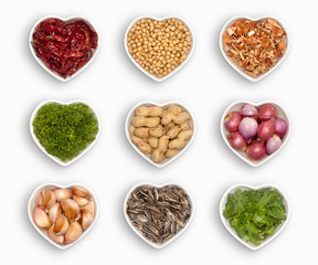 variety of ingredients in a heart shaped bowl, isolated on white.
dried chili, coriander seeds, lemon grass, parsley, peanuts, shallot, garlic, sunflower seeds, fresh coriander