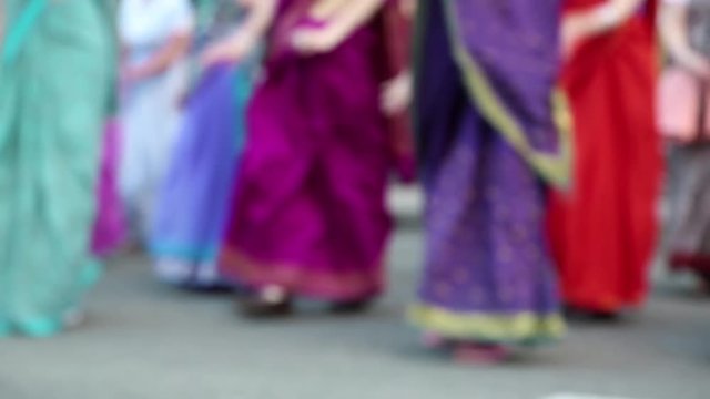 Women in Hindu traditional colorful costumes, dancing on the street, defocused video