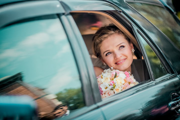 Beautiful Bride in Car on wedding day looking out Window. Bride smile emotions
