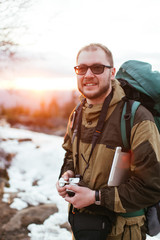 tourist with a camera on a background of a winter landscape in the mountains